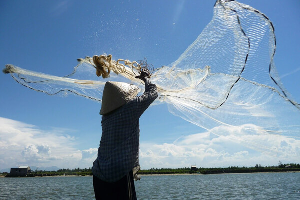 Local cast fishing net in Hoi An river, Vietnam Tours