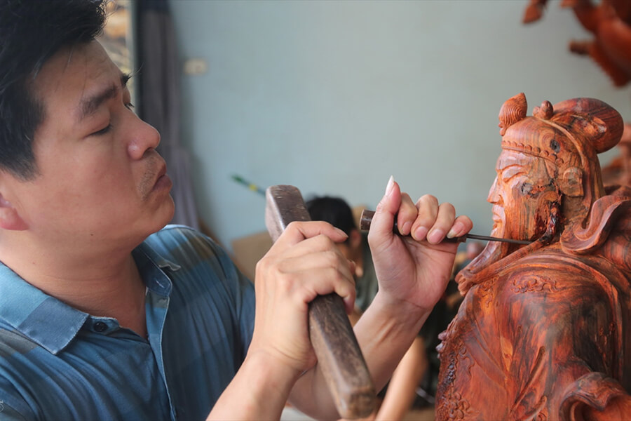 An artisan carving Buddha statue