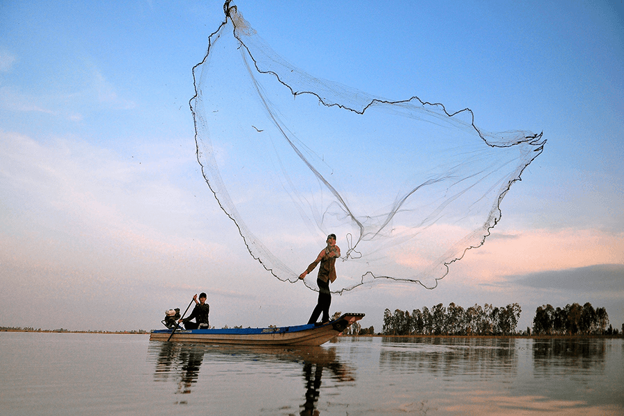 Local cast fishing net in Hoi An river, Vietnam Tours