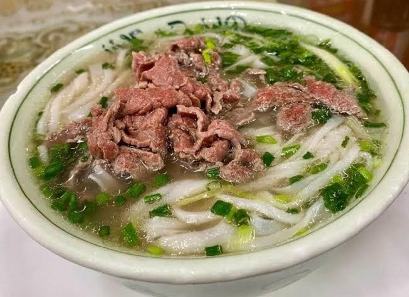 How is pho made using slow-simmered beef bones and Vietnamese spices